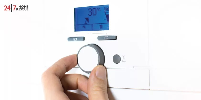A person is turning on the central heating system