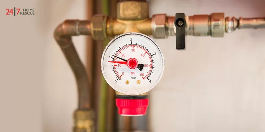 Pressure gauge on a copper pipe showing 1.0 bar, used for monitoring boiler pressure