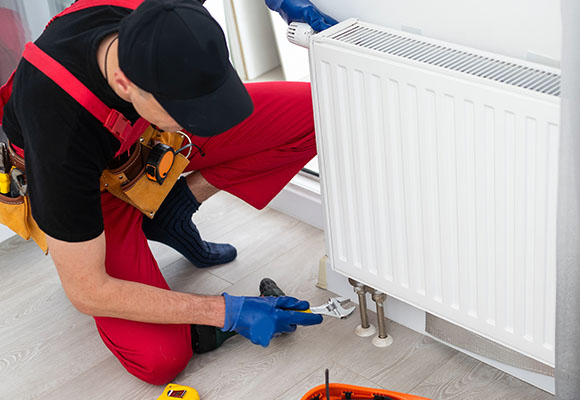 man checking a home radiator for central heating functionality