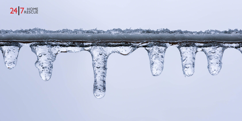 A frozen pipe with hanging icicles, highlighting a common winter plumbing risk
