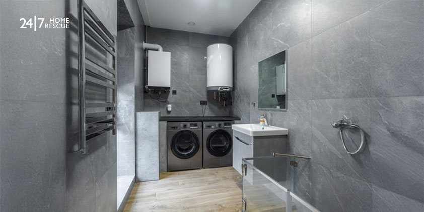 Modern dark grey bathroom with granite tiles and a wall-mounted boiler for heated water.
