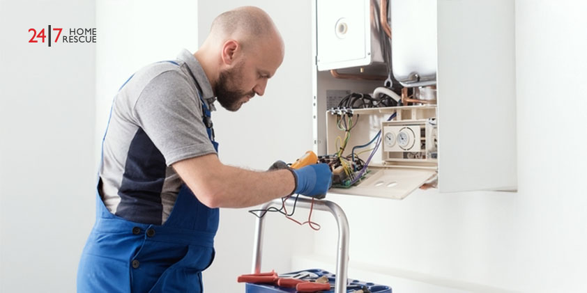 Engineer using a digital multimeter to test a boiler's circuit board