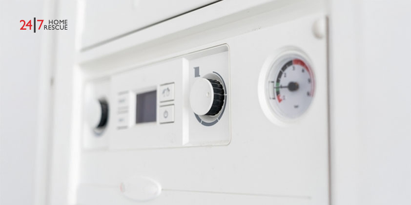 Close-up of a gas boiler control panel in an apartment, showing temperature display and pressure gauge.