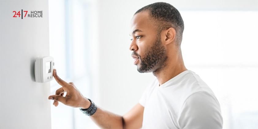 Man adjusting temperature on a smart home thermostat
