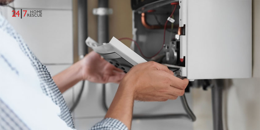 Man opening the top of a gas boiler indoors during inspection