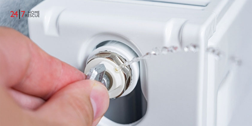 The bleed valve in the radiator to vent air from the radiator. Person's bleeding a radiator to make the heating more efficient. 