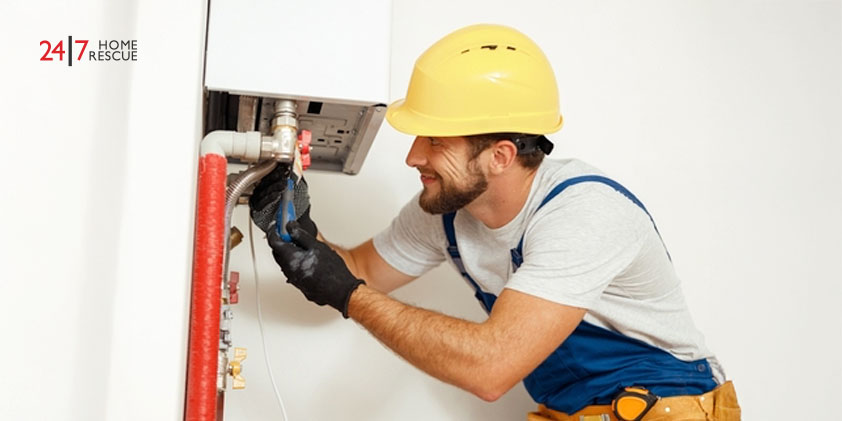 engineer using a screwdriver while fixing boiler 