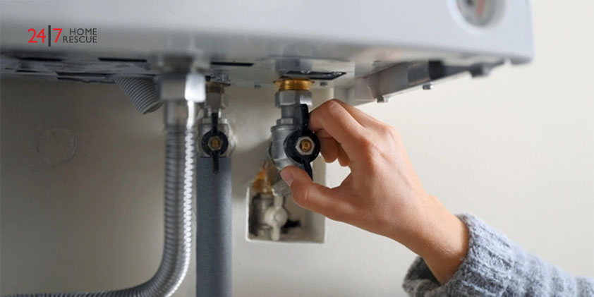 Woman turning on valve of gas boiler