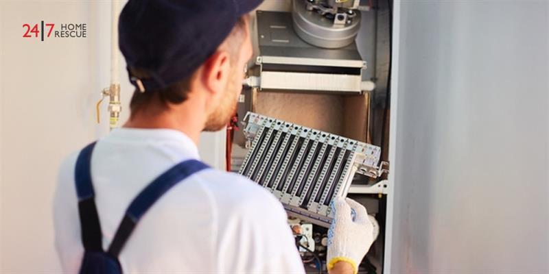 An engineer servicing a boiler to clean burner residue