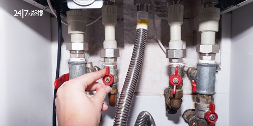 A man checking the gas connection of a modern gas boiler