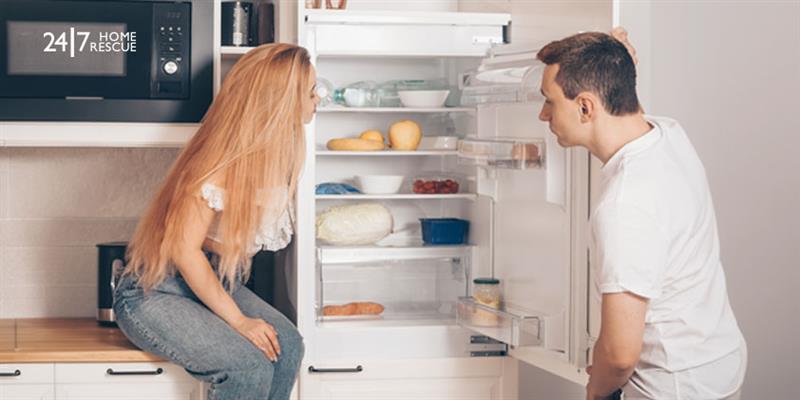 A man and woman worried about the fridge-freezer not cooling properly