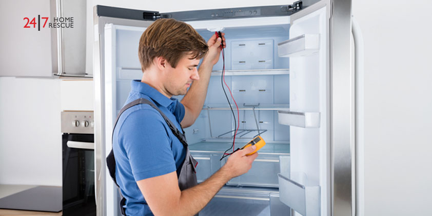 A repairman inspecting a fridge freezer