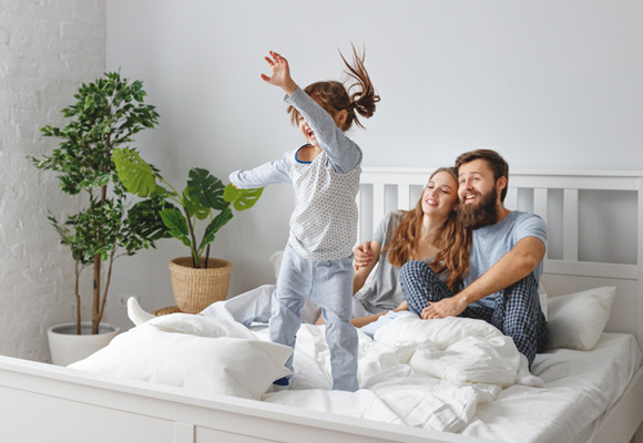 Family enjoying playtime together in a warm bedroom